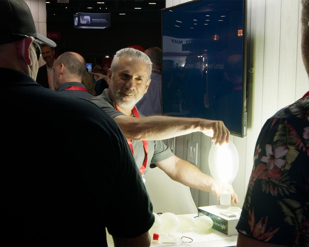 A man shows off an LED luminaire at Lightfair International